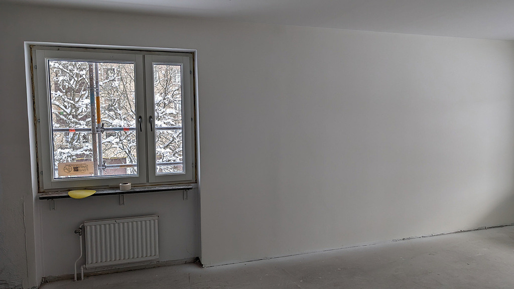 Bild på ett rum med nya fönster och vitmålade väggar och tak.
